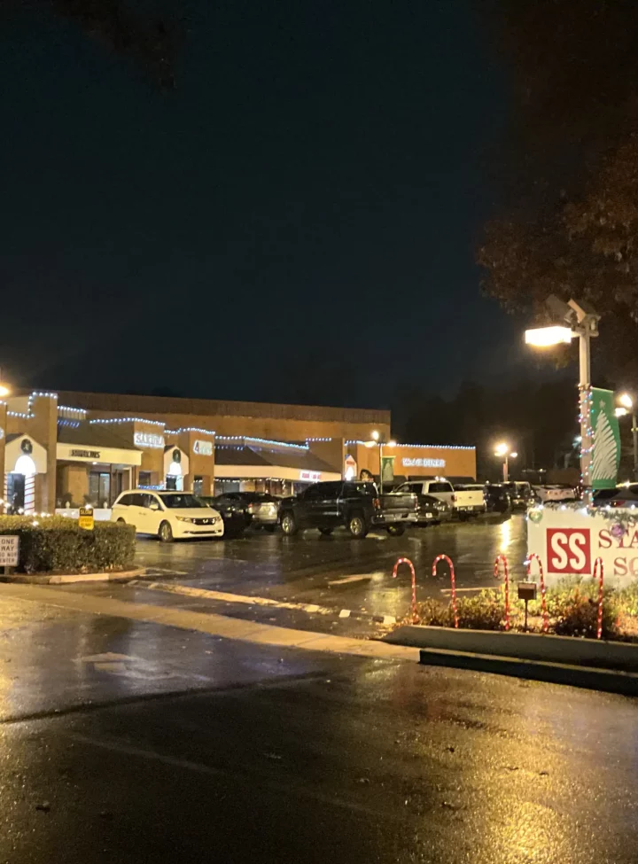 A nighttime view of Stansell Square commercial plaza with festive lighting and decorations.