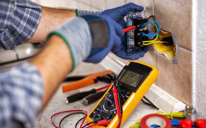 Electrician at work with screwdriver fixes the cable in the sockets of a residential electrical system